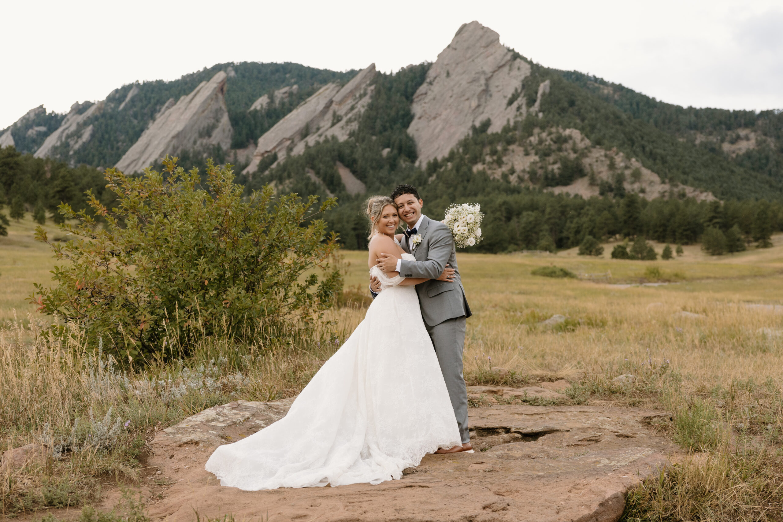 A newlywed couple shares a smile and embrace at Chautauqua Park in Boulder where they held their elopement ceremony. 
