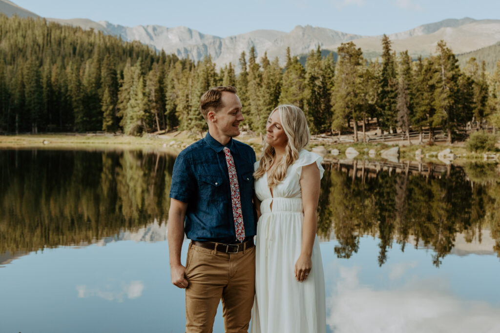 A bride and groom smile at each other with Echo Lake behind them.