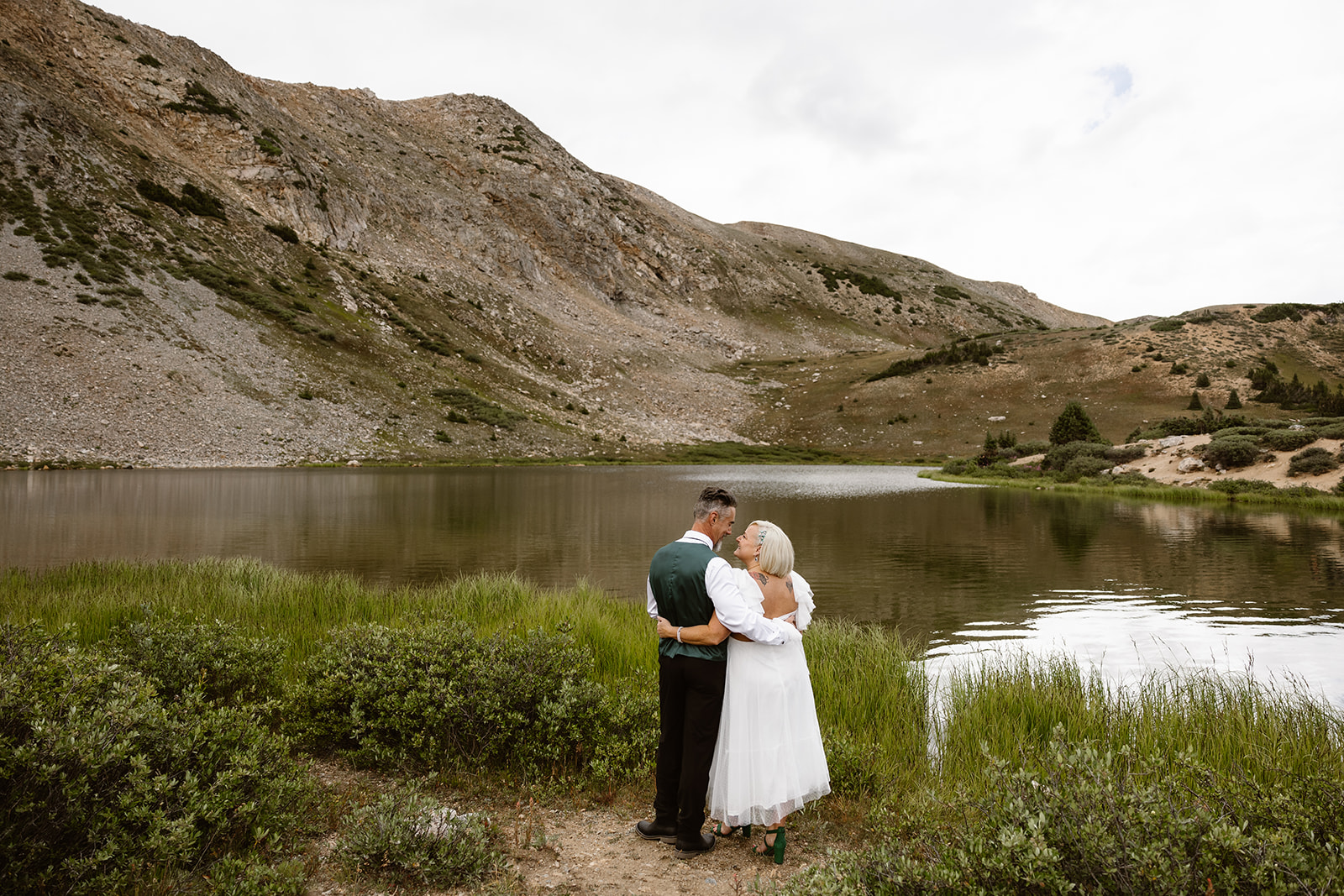 A bride and groom enjoying the lake view at Loveland Pass near Breckenridge Colorado